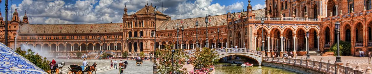 Ansicht des Plaza de España in Sevilla mit Kanal, Booten und Besuchern.