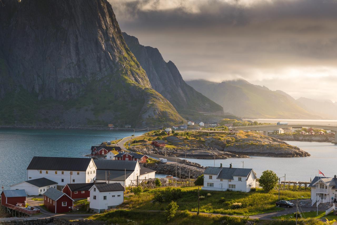 Küste und Berge auf Lofoten mit Häusern im Vordergrund.