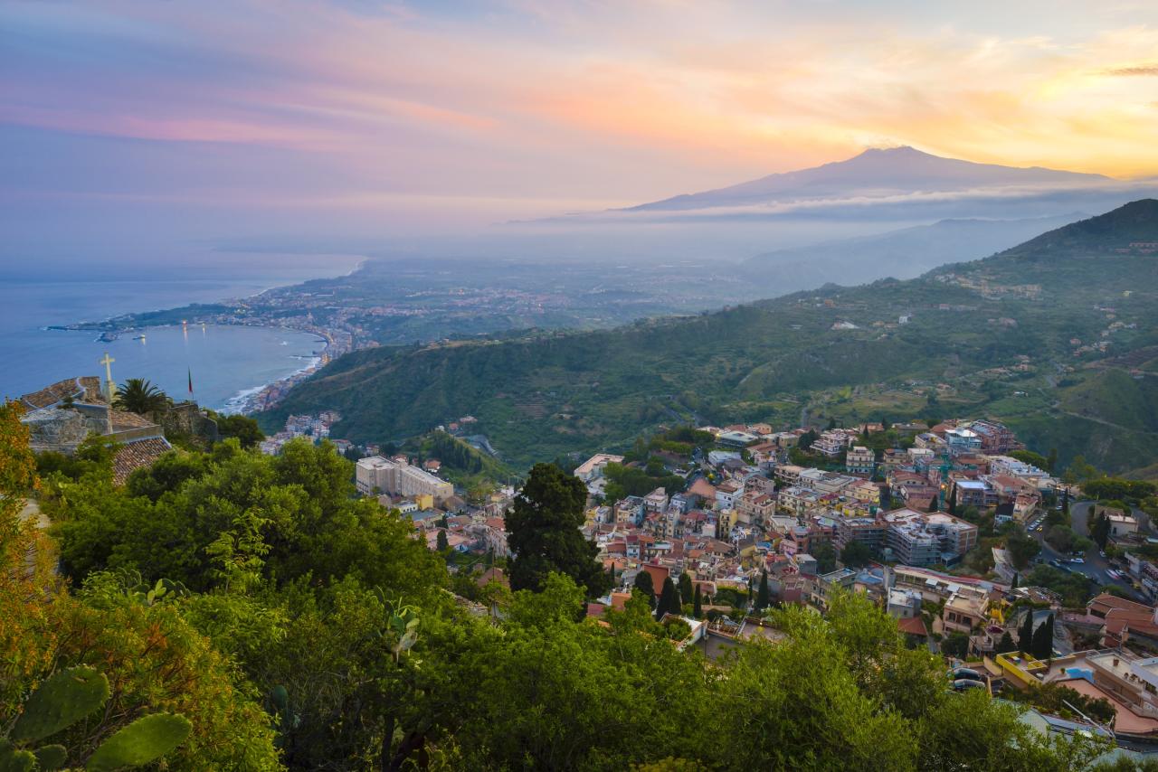 Blick auf Taormina am Abend mit Vulkan Ätna im Hintergrund.