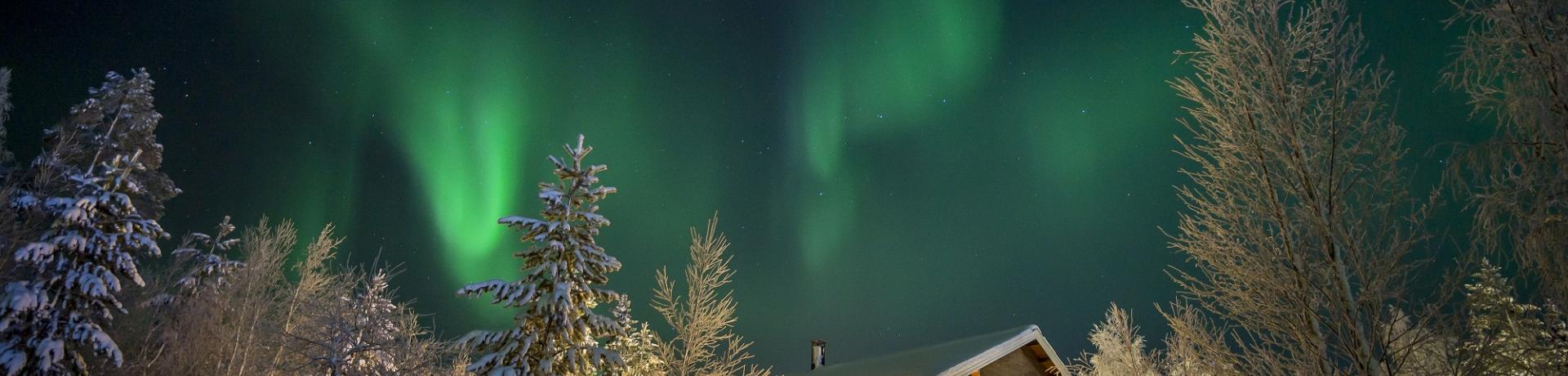 Haus im Schnee mit Polarlichtern