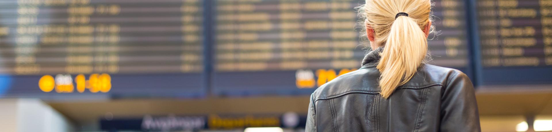 Flugverspätung: Flughafen - Anzeigetafel - Frau - Emotion