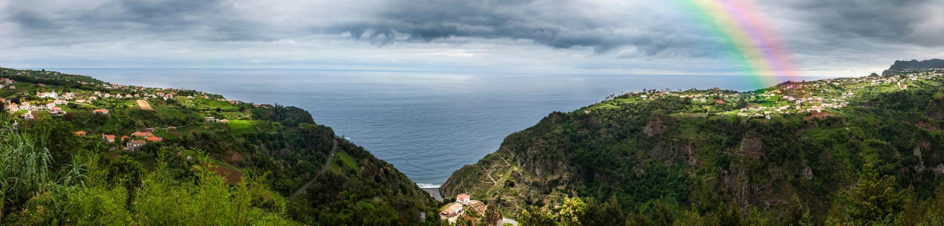 Blick von der Küste Madeiras aufs Meer mit Regenbogen.