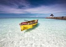 Fischer Kajak an der Nordküste Jamaikas in klarem Wasser mit Steg und Pavilion im Hintergrund.