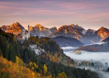 Neuschwanstein - Bayern Schloss Neuschwanstein umgeben von Herbstlaub bei Sonnenaufgang.
