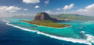Luftaufnahme der Halbinsel Le Morne Brabant auf Mauritius, umgeben von türkisfarbenem Wasser.