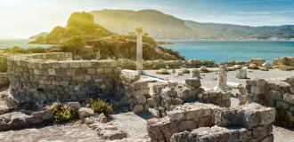 Antike Ruinen auf Kos mit dem Meer und Bergen im Hintergrund.