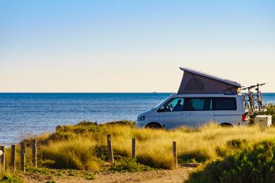 Campervan mit Dachzelt am Strand