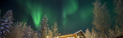 Haus im Schnee mit Polarlichtern
