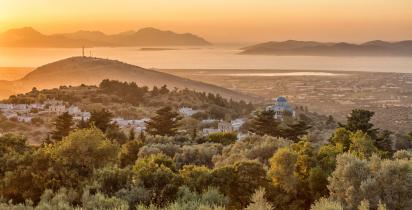 Zia - Kos Hügellandschaft auf Kos bei Sonnenuntergang mit dem Meer im Hintergrund.