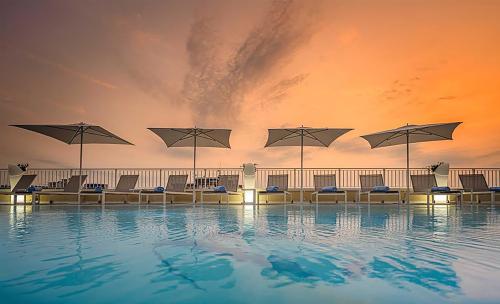 Liegen am Pool bei Sonnenuntergang