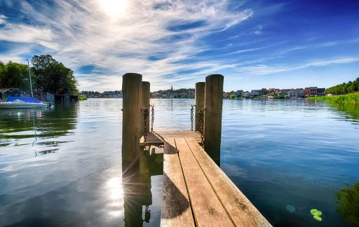 Malchow Blick von einem Steg auf einen See mit Stadt im Hintergrund.