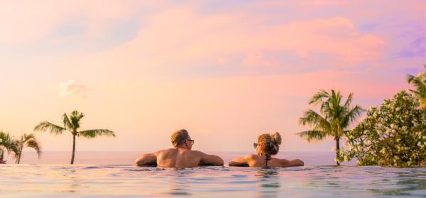 Paar im Pool bei Sonnenuntergang