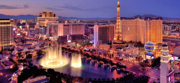 Blick auf die beleuchteten Bellagio Fountains bei Nacht, mit dem Las Vegas Strip im Hintergrund.