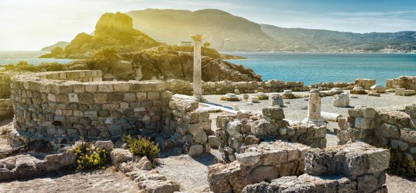 Antike Ruinen auf Kos mit dem Meer und Bergen im Hintergrund.