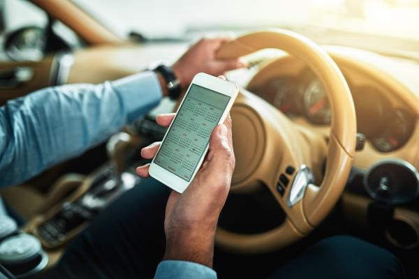 Mann im Auto am Smartphone