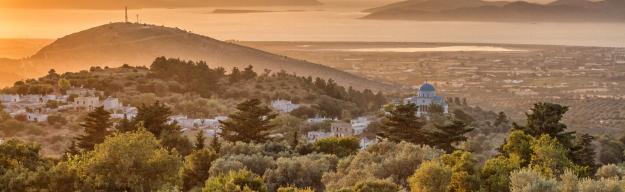 Hügellandschaft auf Kos bei Sonnenuntergang mit dem Meer im Hintergrund.
