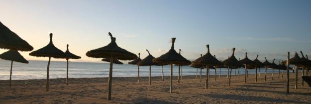Leerer Strand mit Sonnenschirmen