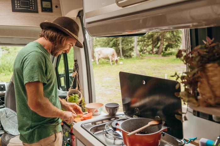 Mann kocht im Camper