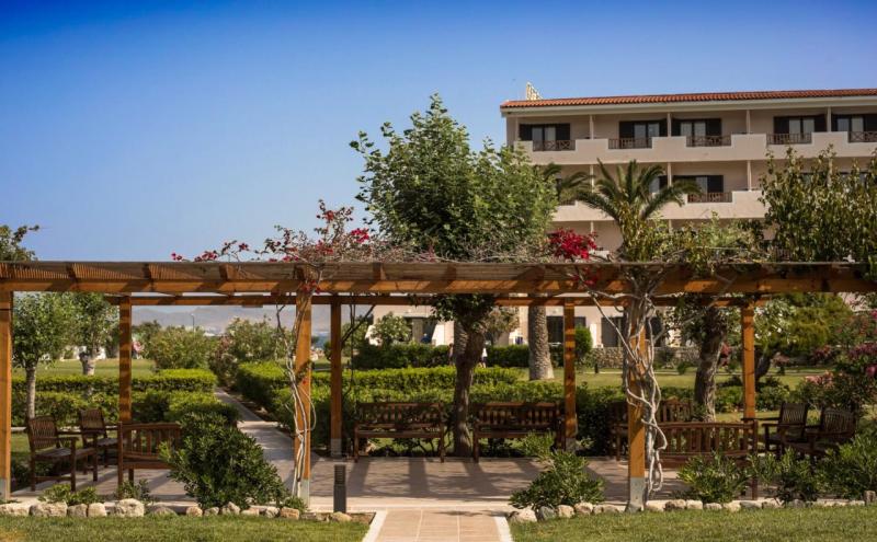 Grüne Gartenanlage mit schattiger Pergola im Mitsis Ramira Beach Hotel auf Kos