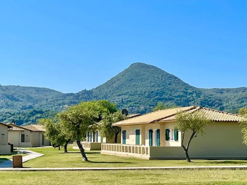 Bungalowanlage des Mitsis Messonghi Beach Resorts auf Korfu mit Blick auf grüne Hügel und mediterrane Landschaft