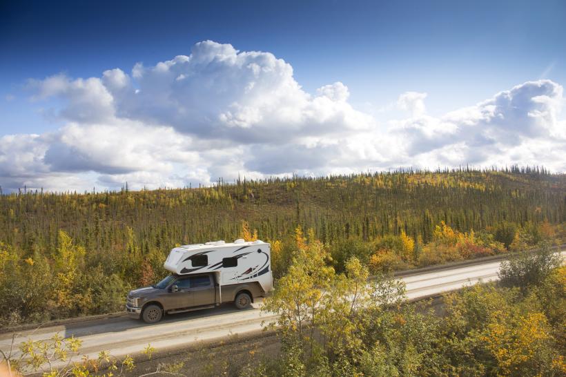 Pickup-Camper fährt vor einem Berg