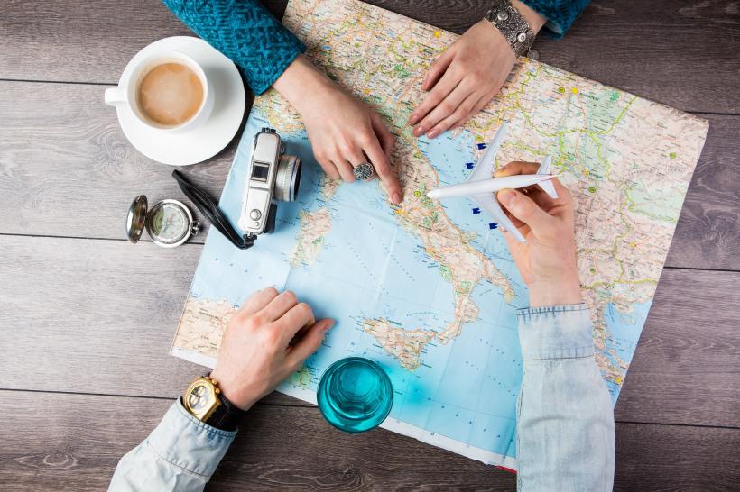 Menschen suchen Urlaubsziel auf Karte