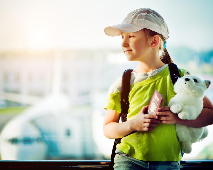 Kind am Flughafen mir Reisepass