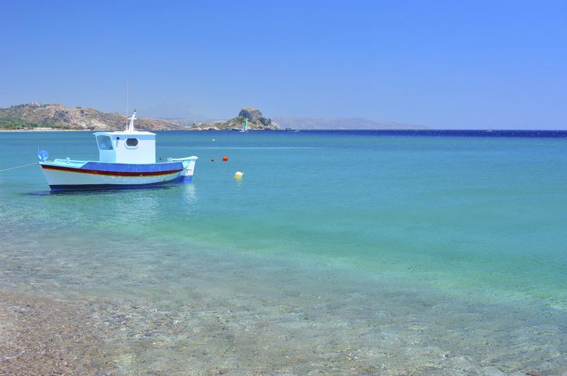 Boot ankert vor Strand