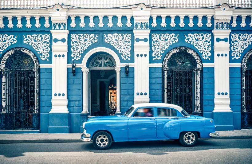 Blauer Oldtimer vor blauem Haus