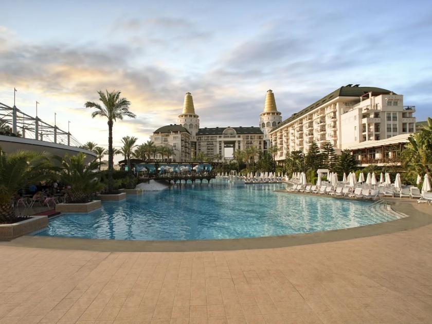 Luxuriöses 5-Sterne-Resort mit großem Pool und Palmen bei Sonnenuntergang