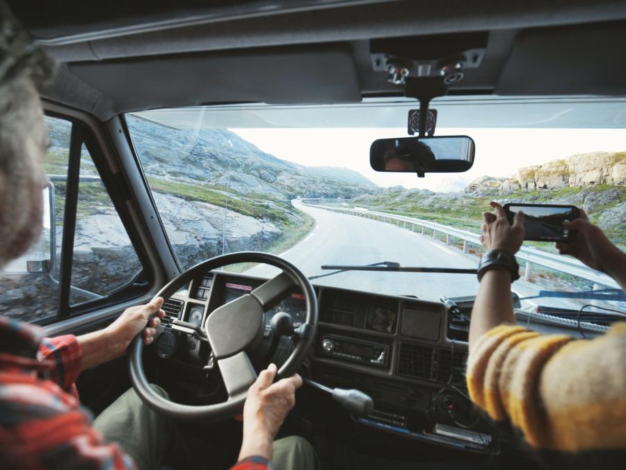 Personen im Camper fahren über Gebirgspass