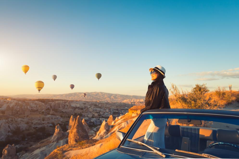 Frau vor Landschaftkulisse mit Heißluftballons Frau vor Landschaftkulisse mit Heißluftballons