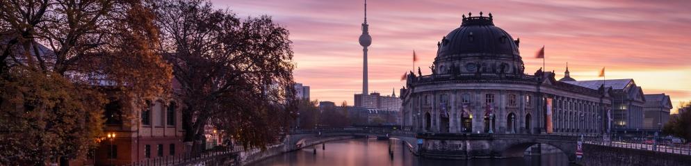 Prachtvolles Gebäude am Fluss im Sonnenuntergang