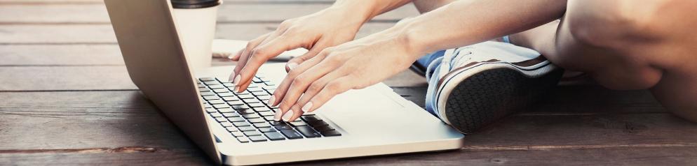 Frau tippt in Laptop