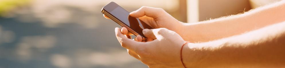 Hände bedienen ein Smartphone.