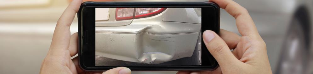 Jemand fotografiert Schaden am Auto Jemand fotografiert Schaden am Auto