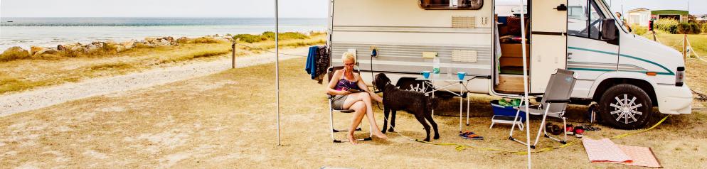 Camping mit Hund am Meer Hund und Frau vor Wohnmobil