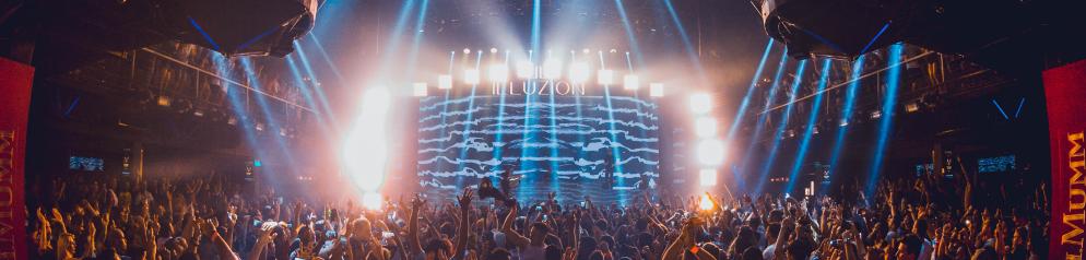 Jubelnde Menschen vor einer Bühne im Illuzion Club