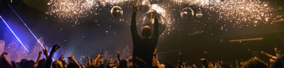 Feiernde Menschen im Club mit einer Person, die alle überragt