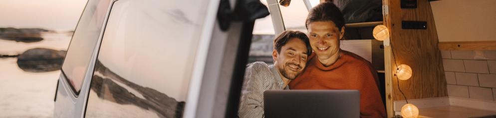 Paar vor Laptop im Camper