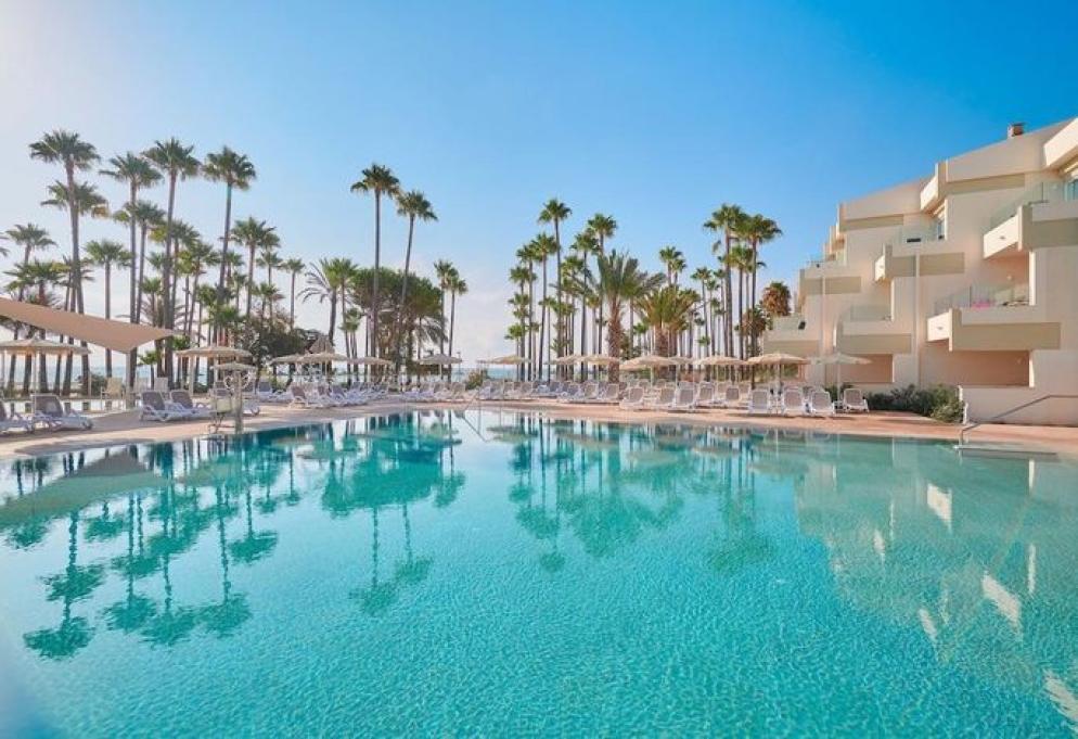 Hotelpool mit Liegen und Palmen