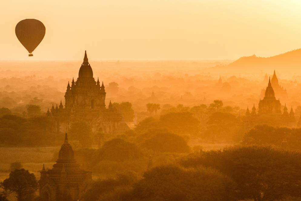Heißluftballon über Tempel bei Sonnenuntergang