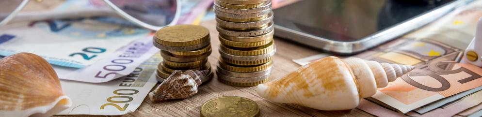 Geld und Muscheln auf Tisch