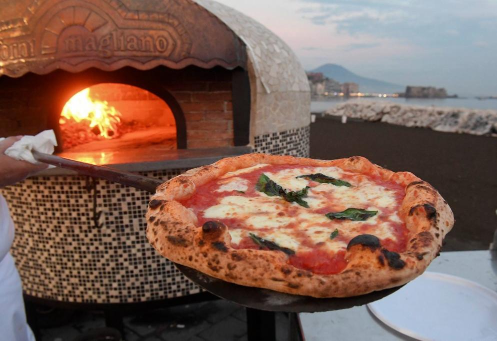 Frische Pizza vor Steinofen