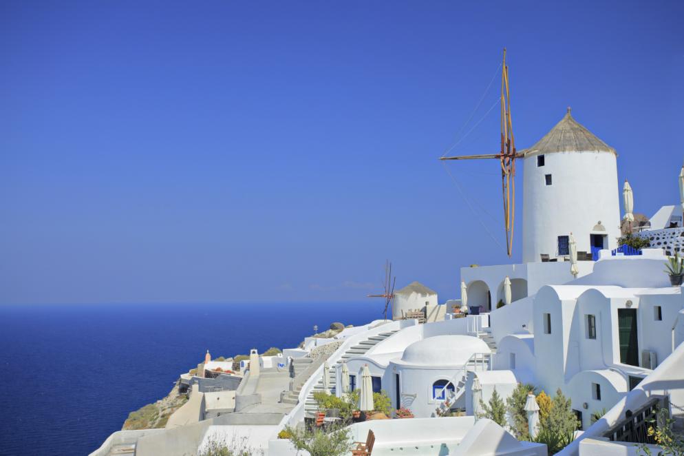 Weiße Häuser und Mühle vor Meer Weiße Häuser und Mühle vor Meer