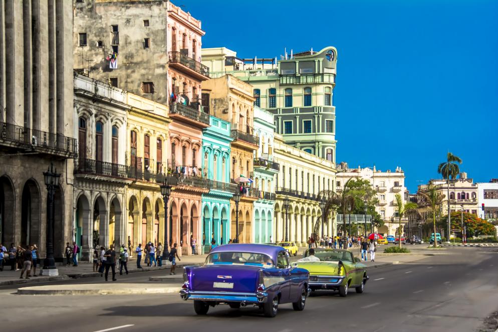 Straße in Havanna mit historischen bunten Häusern und Oldtimer-Autos.